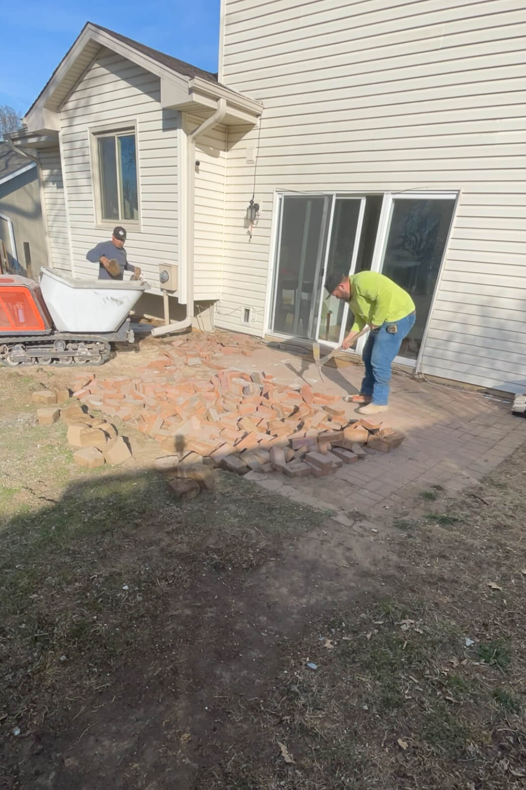 Removing old pavers from a patio.